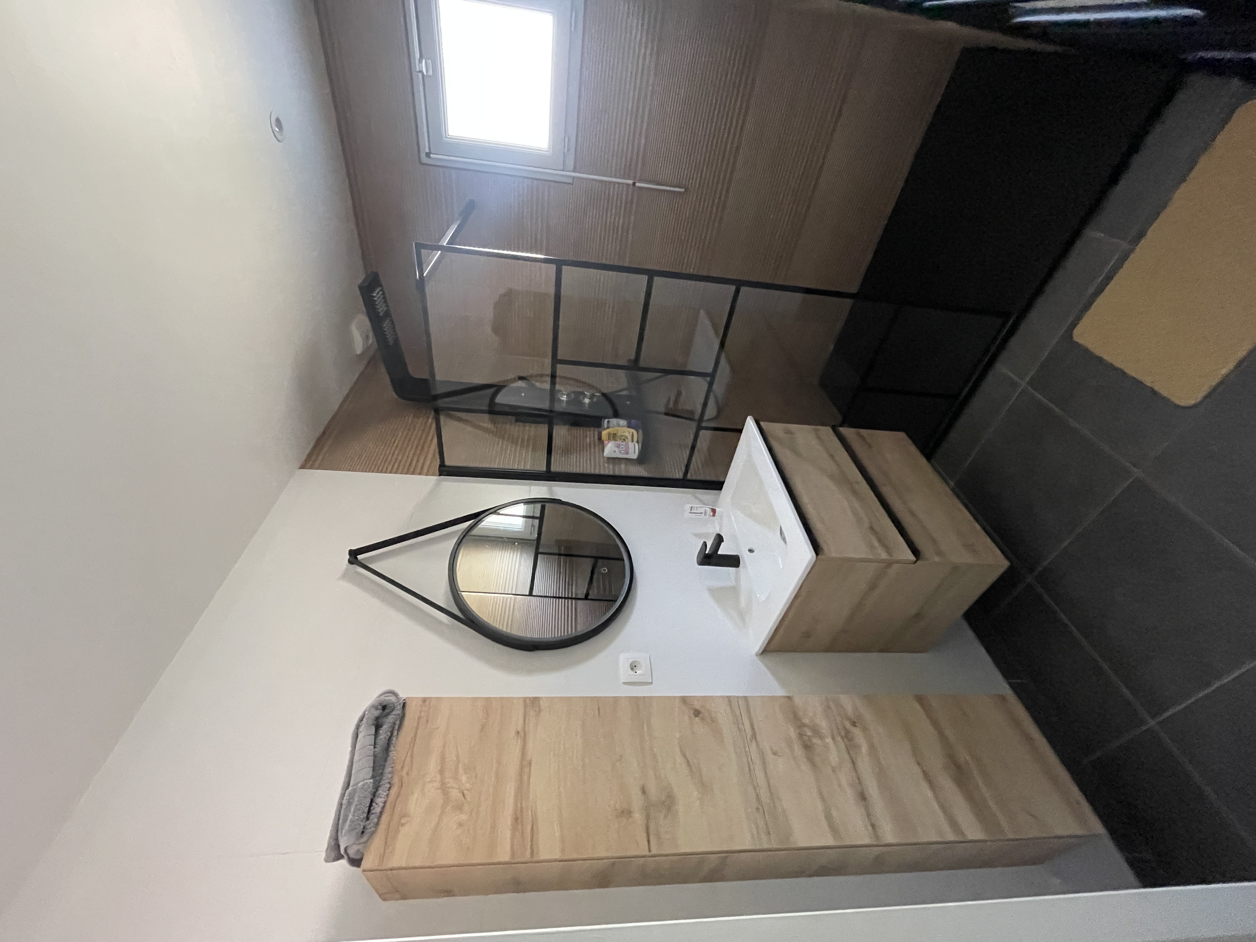 Salle de bain rénovée à Angers — meuble vasque bois et miroir rond — C.R.A.C